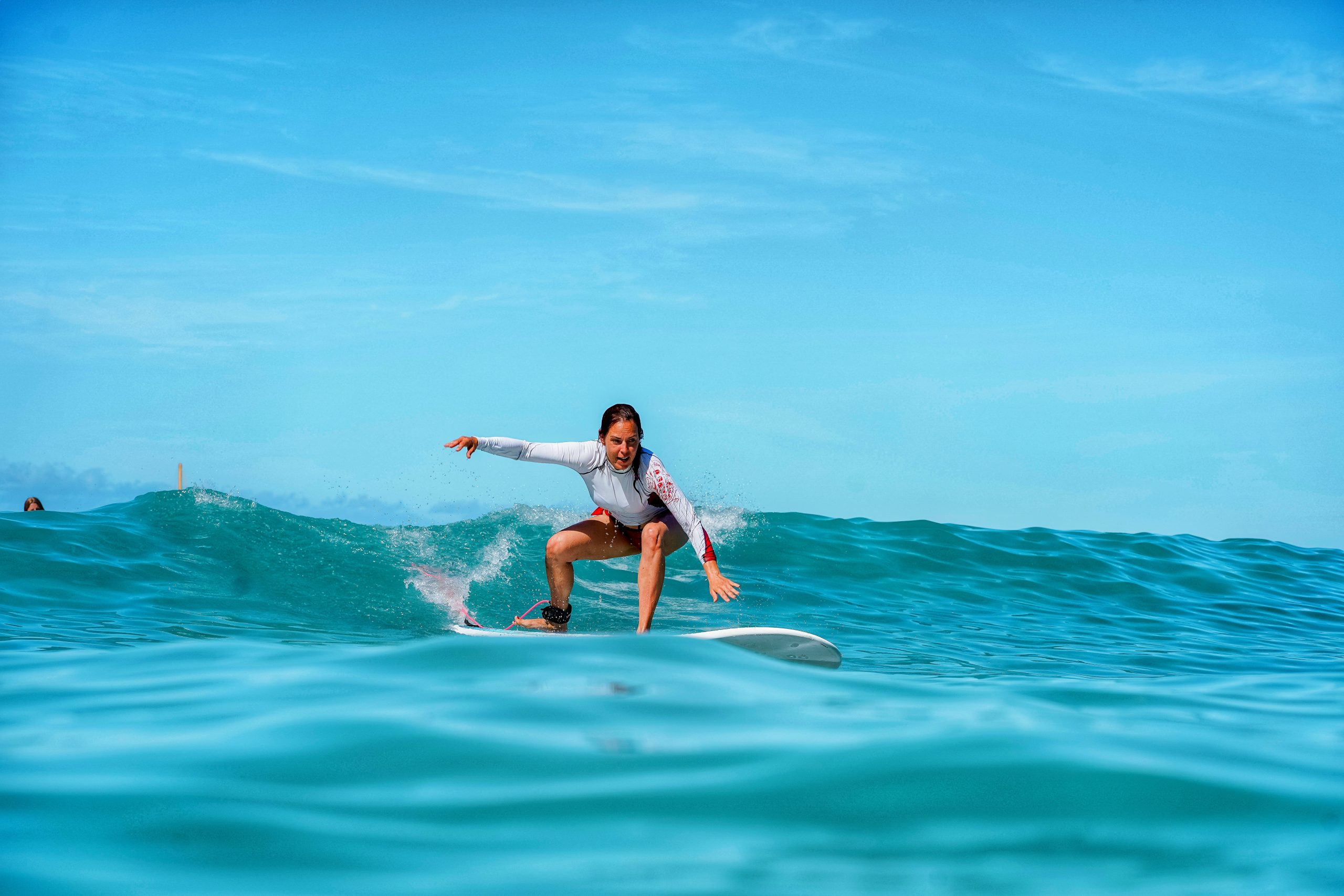 Denise Mayer surft auf dem Surfbrett über das Meer